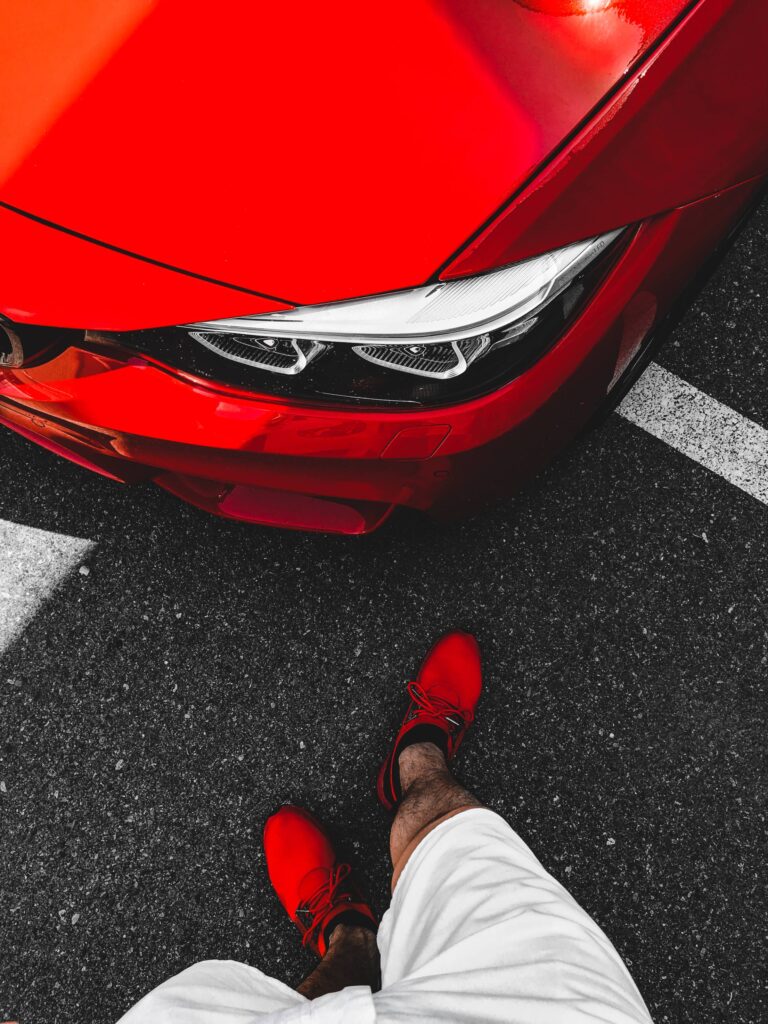 Man in Red Shoes Standing in Front of Ferrari-Red BMW Free Photo