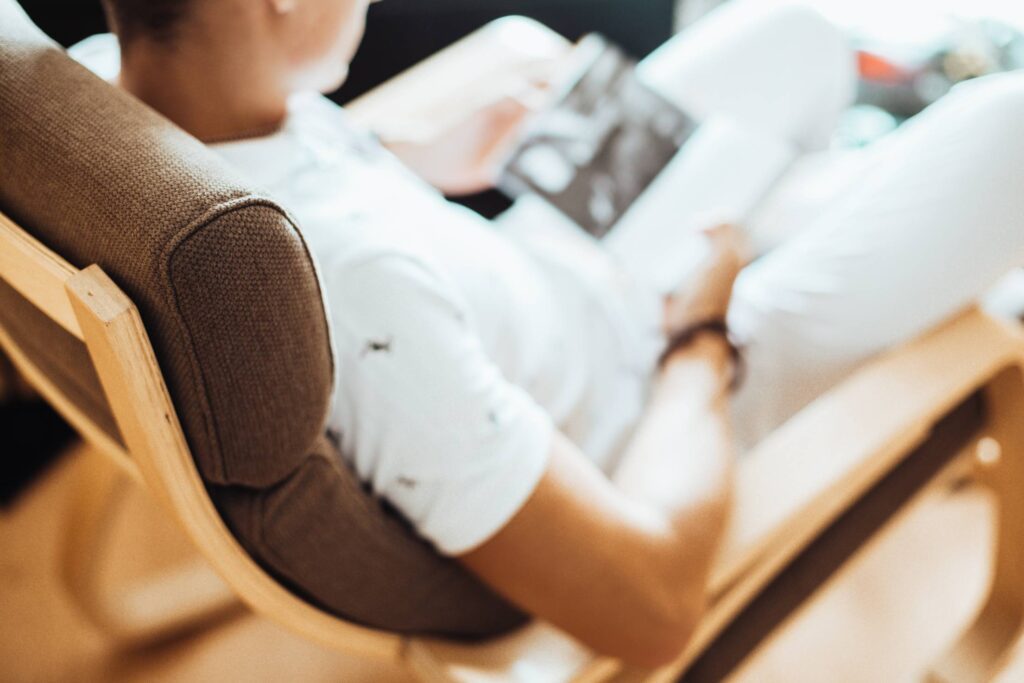 Man Reading a Book in a Chair Free Photo