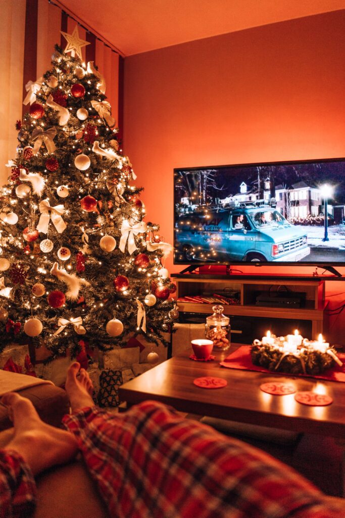 Man Relaxing in a Living Room and Watching a Christmas Movie in the Evening Free Photo