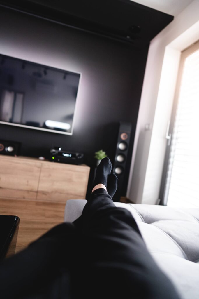 Man Relaxing on a Sofa in a Home Theater Living Room Free Photo