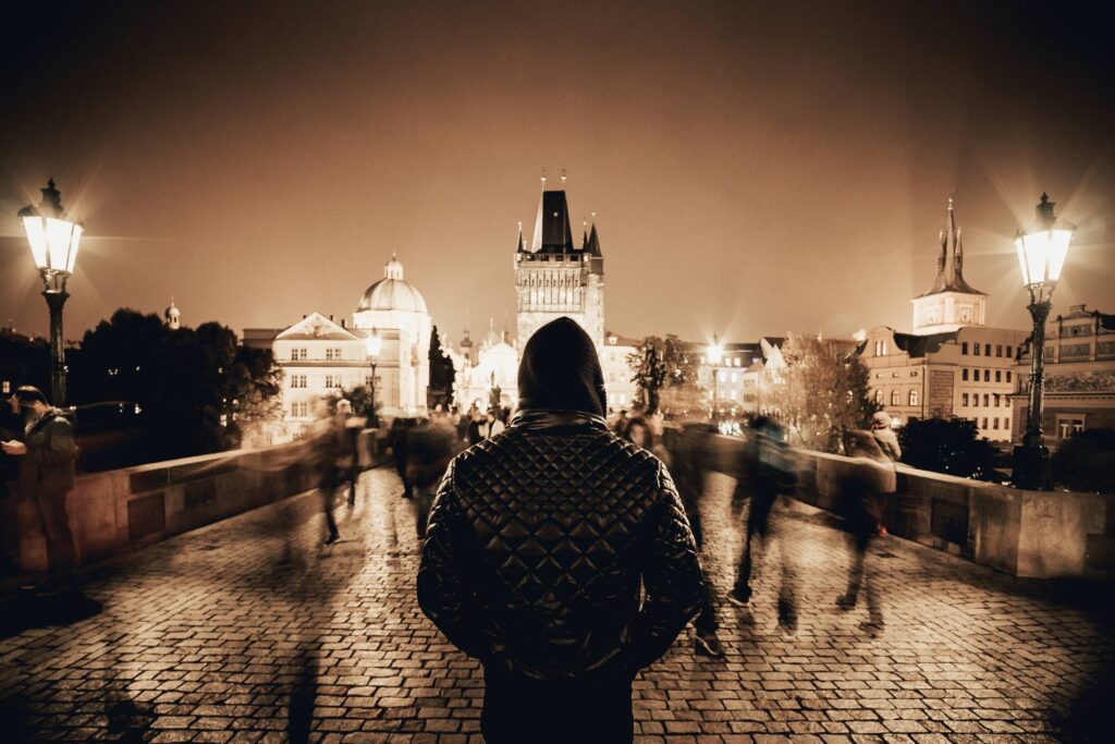 Man Standing on Prague’s Charles Bridge in Sepia Tone Free Photo