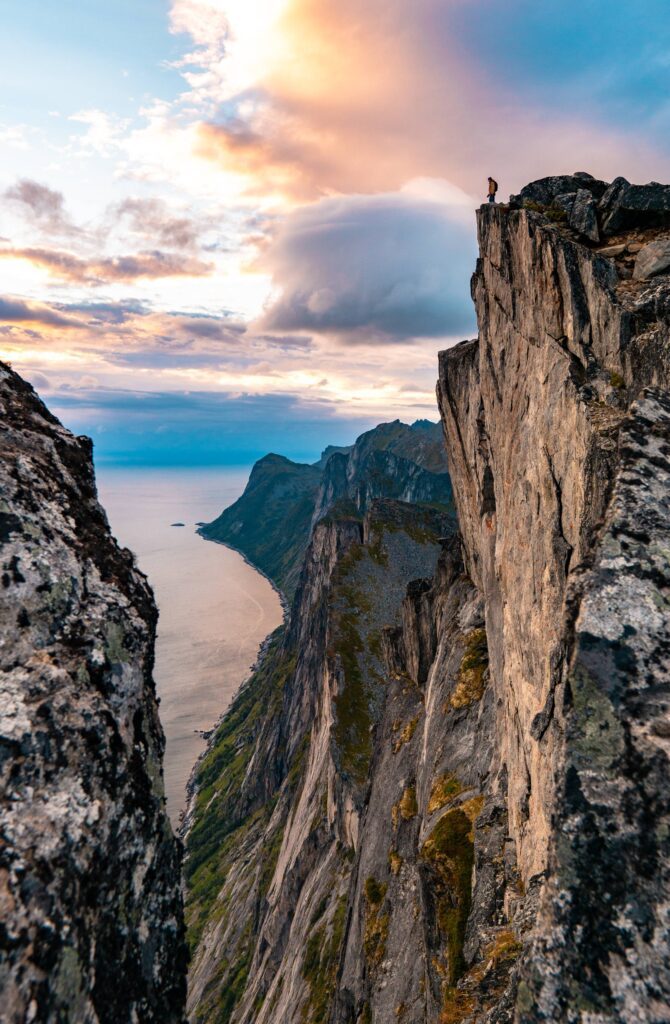 Man Standing on the Edge of the Cliff on Senja Island Free Photo