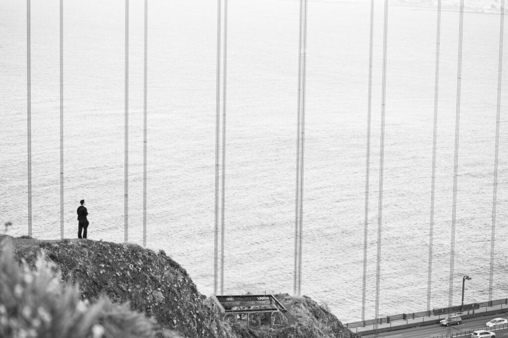 Man Stands at The Edge of The Cliff Near The Golden Gate Bridge Free Photo