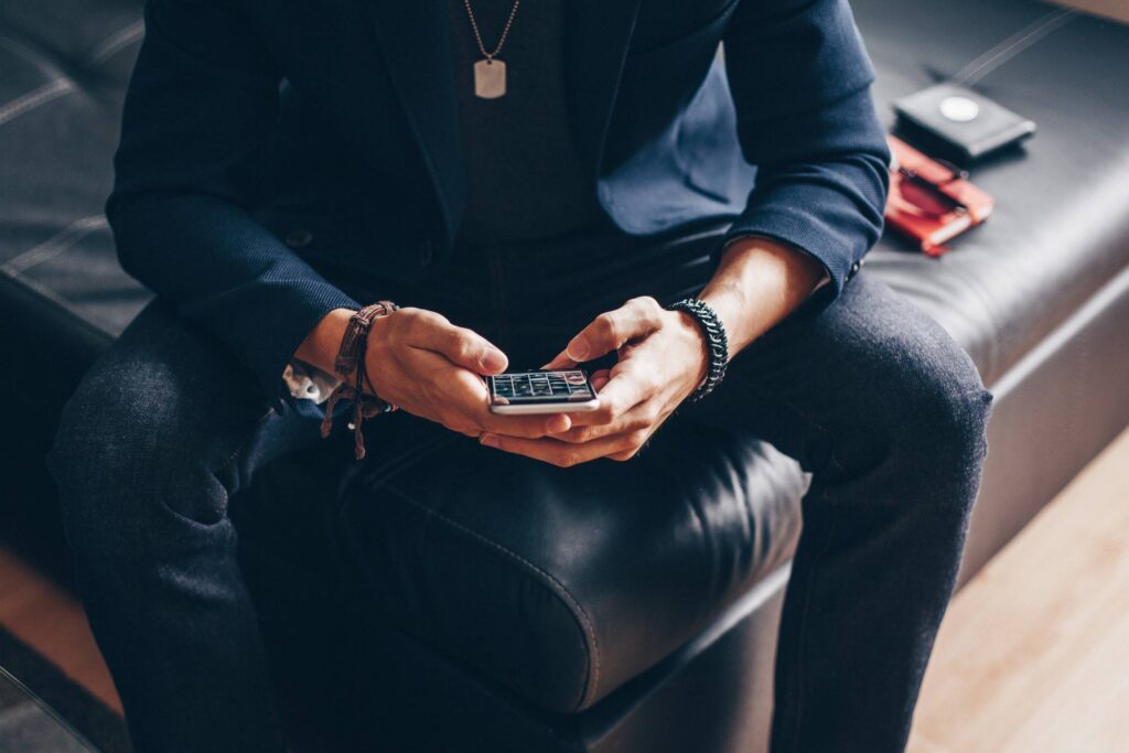 Man Using his iPhone 6 on a Sofa Free Photo