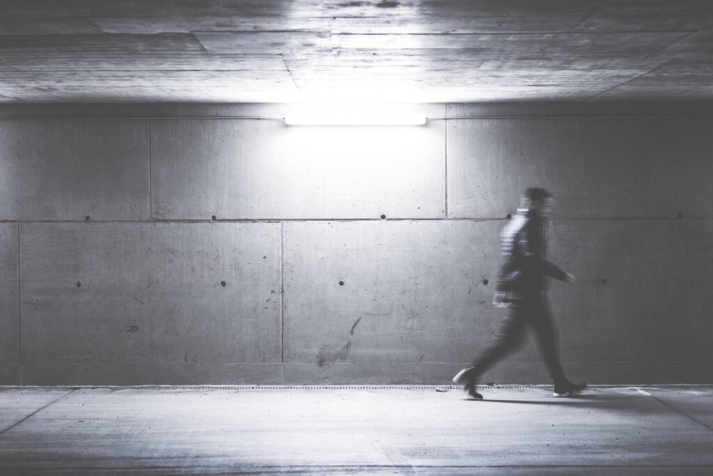 Man Walking Through Concrete Underpass Free Photo