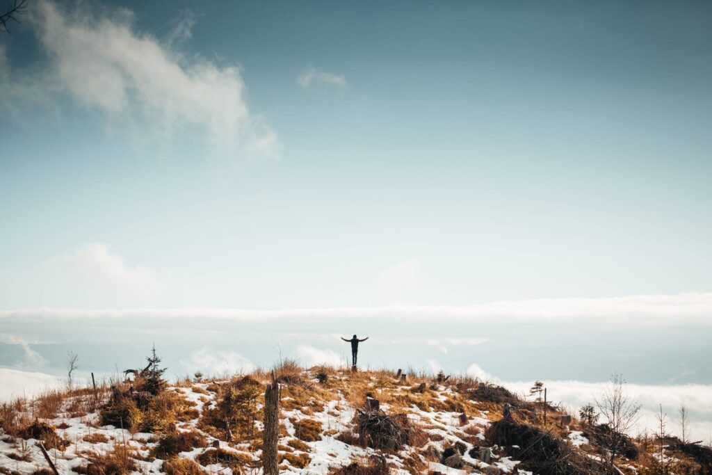 Man With Open Arms on The Top of The Mountain Free Photo