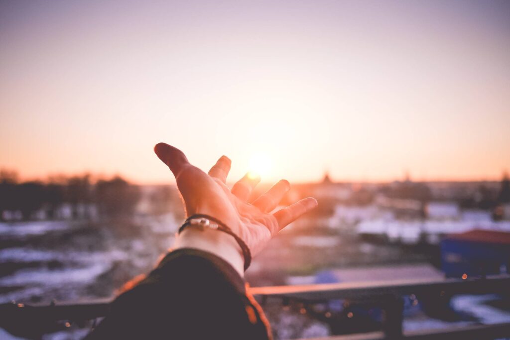 Man’s Hand is Trying To Reach The Sun Free Photo