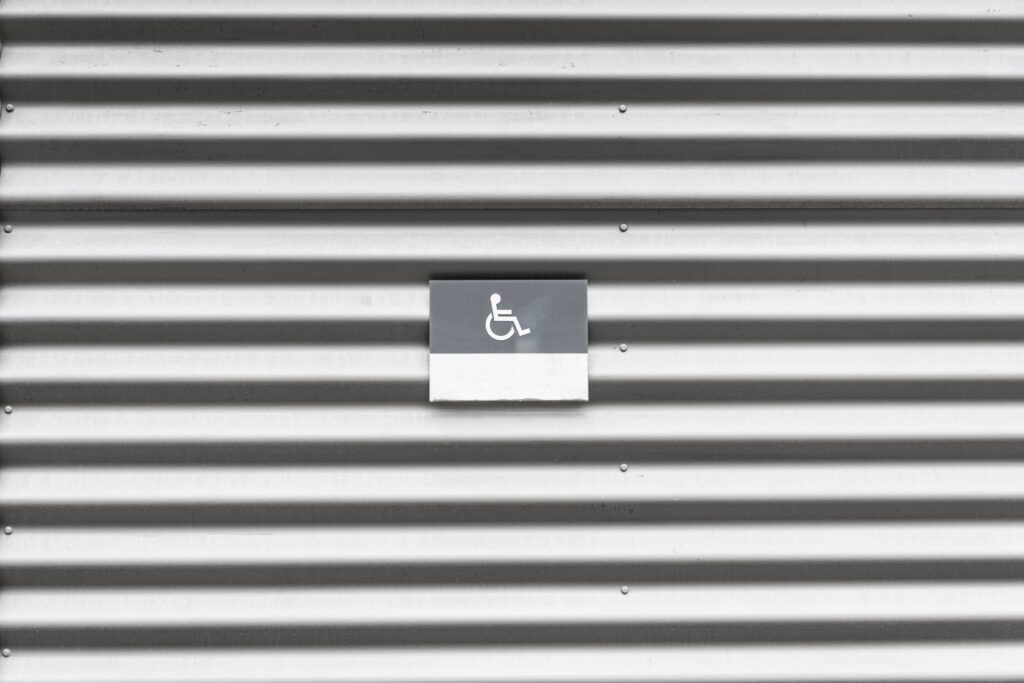 Metal Wall with Wheelchair Disabled Sign Free Photo