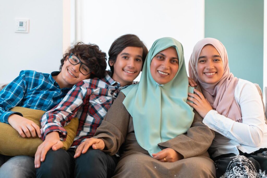 Middle eastern family portrait single mother with teenage kids at home in living room. Selective focus Stock Free