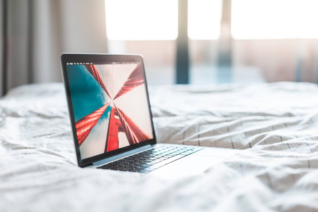 Modern Laptop Against Hotel Room Window Free Photo