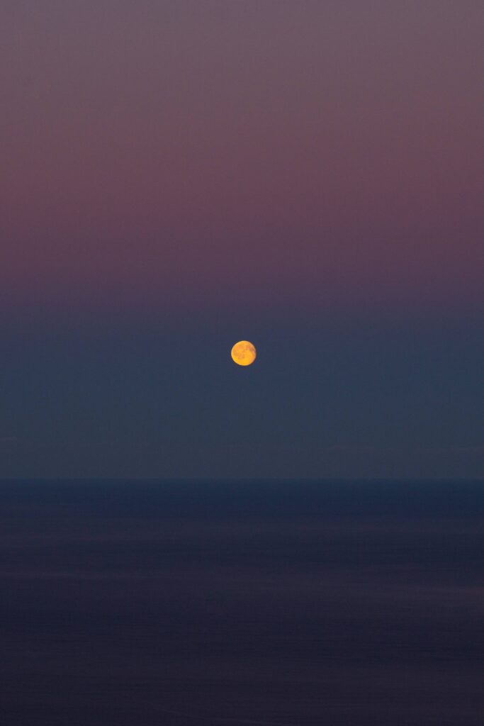 Moon over The Sea on a Colorful Dawn Sky Free Photo