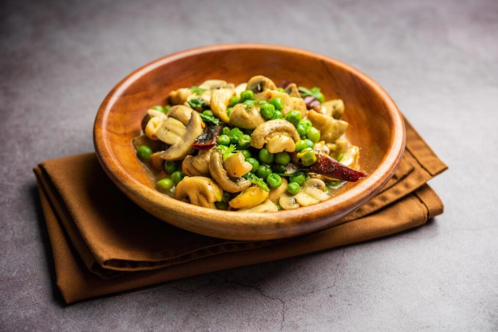 Mushroom and Pea Curry with Roasted Garlic, Indian food served in a bowl Stock Free