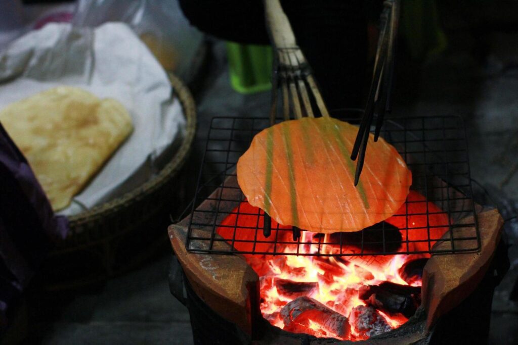 ndigenous rice cracker on stove on street food night market at Thailand Stock Free