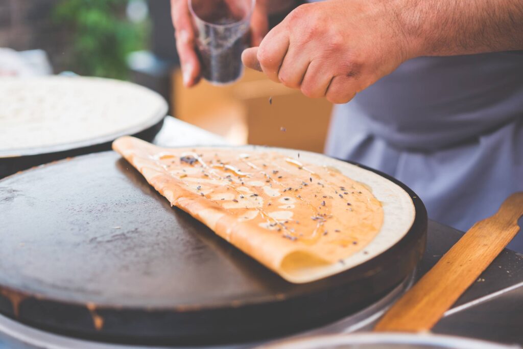 Old Man Making Healthy Crepes in Open Air Market Free Photo