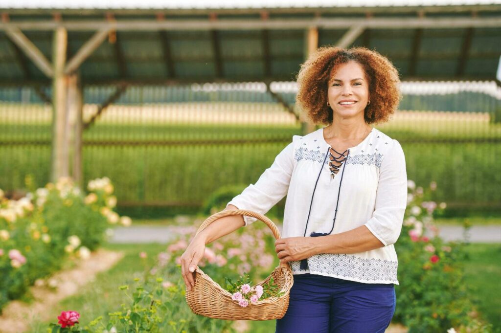 Outdoor portrait of beautiful 50 year old woman enjoying nice day in flower park or garden, happy and healthy lifestyle Stock Free