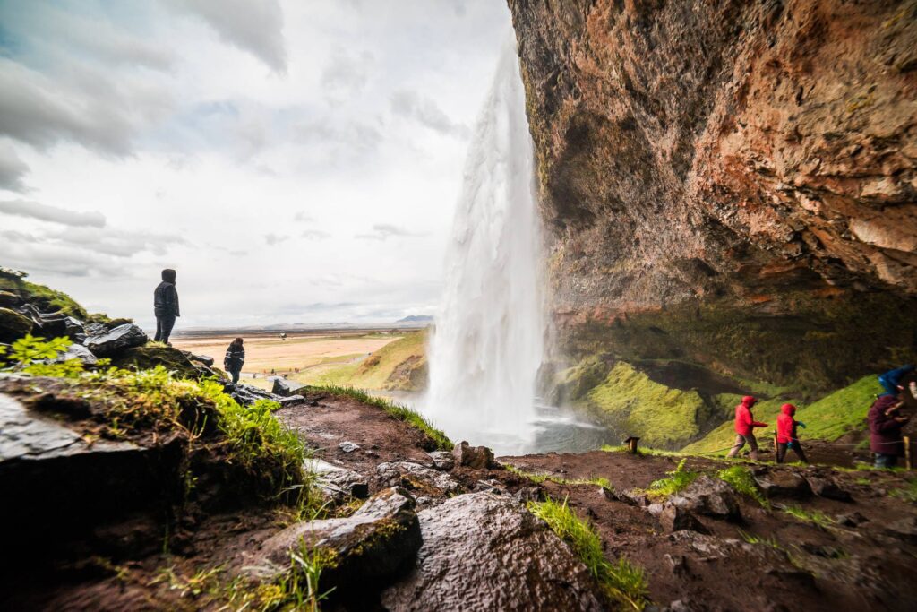 People Under Seljalandsfoss Waterfall in Iceland Free Photo