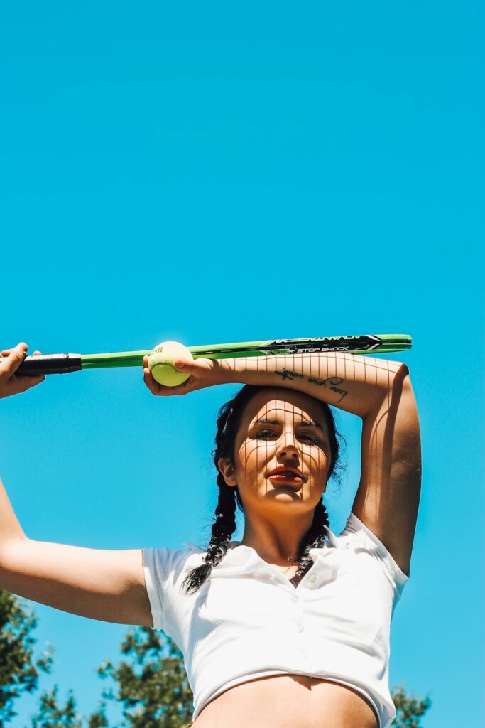 woman in white shirt holding golf club