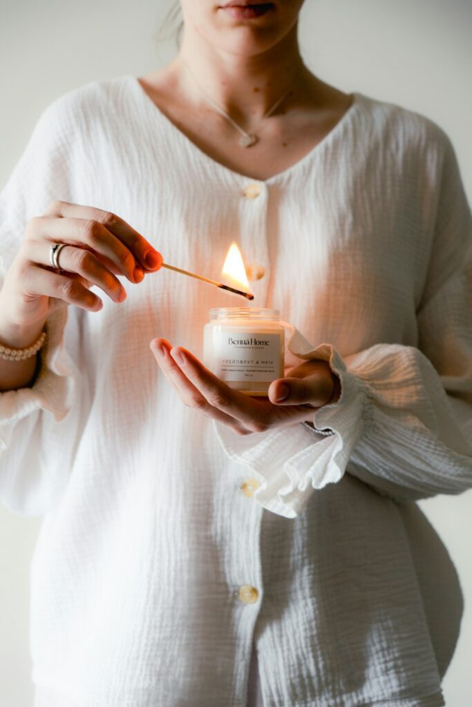 a woman holding a lit candle in her hands