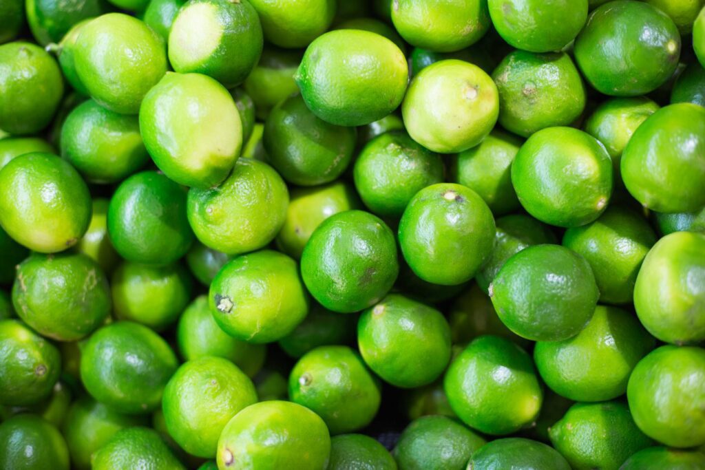 Pile of Green Limes on Market Pattern Free Photo