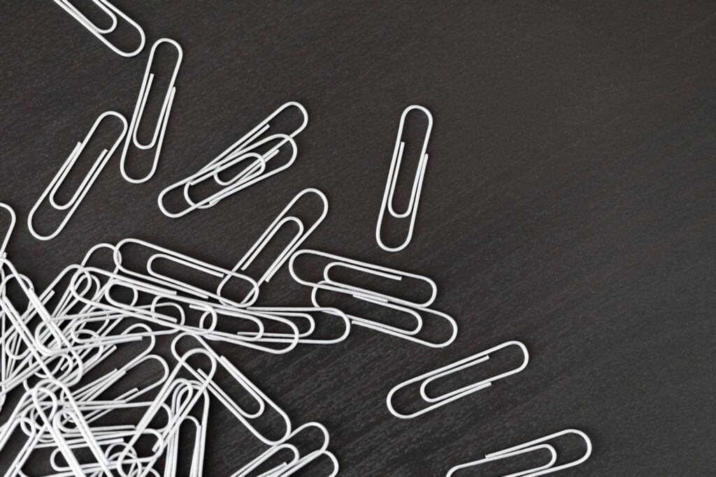 Pile of Silver Paper Clips on Black Desk Free Photo