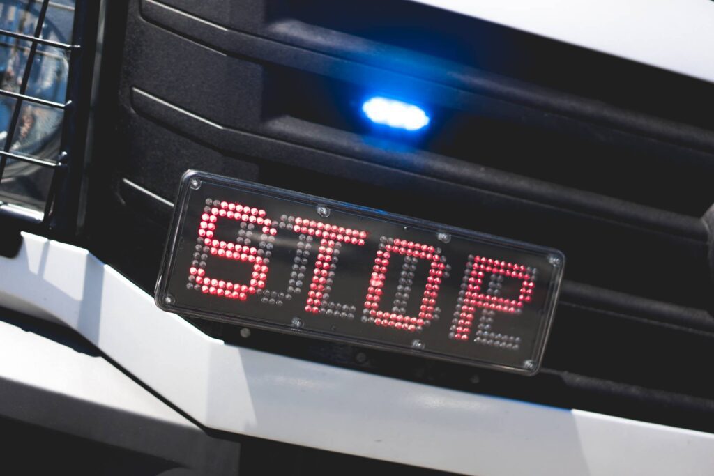 Police Flashing Light and STOP Sign on Car Free Photo