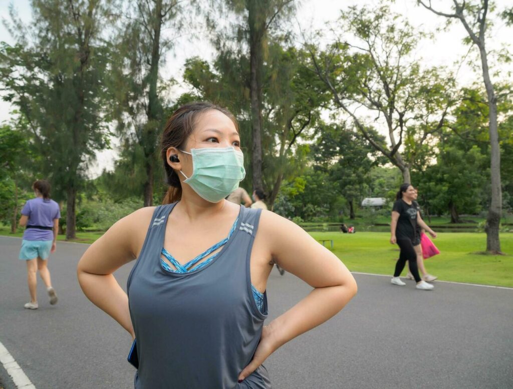 Portrait of a beautiful Asian woman in sportswear, standing with her back, stretching before exercising outdoor in the park in the morning to achieve a healthy lifestyle. healthy warming up Stock Free