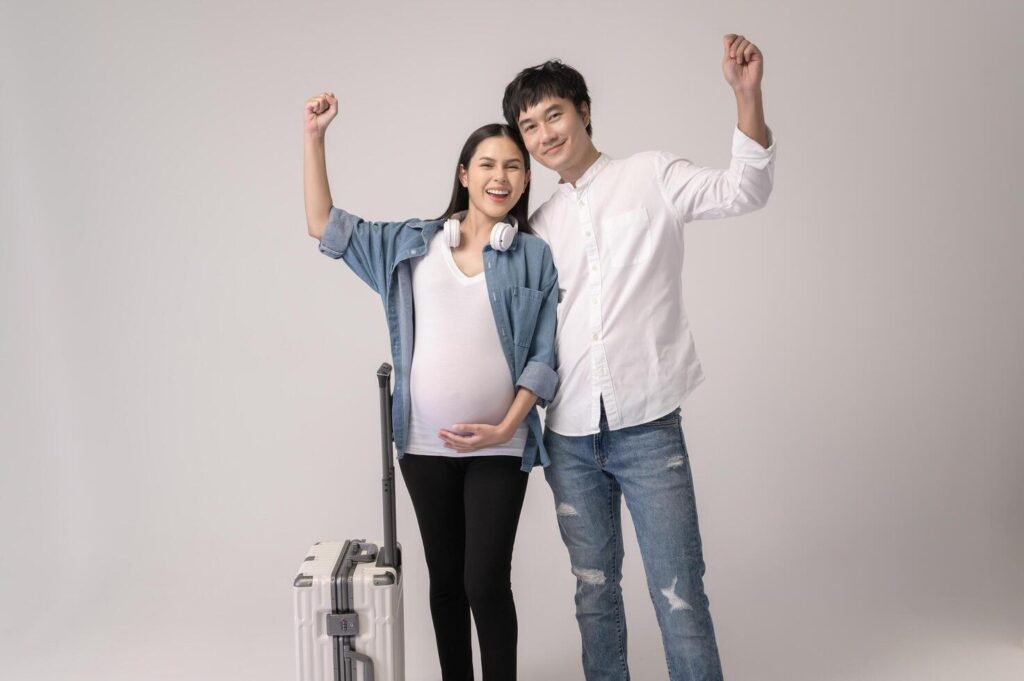 Portrait of Beautiful pregnant woman and husband traveling over white background studio, insurance and maternity concept Stock Free