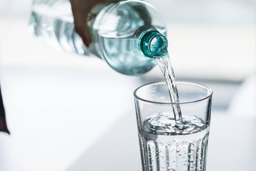 Pouring Water from PET Bottle into a Glass Free Photo