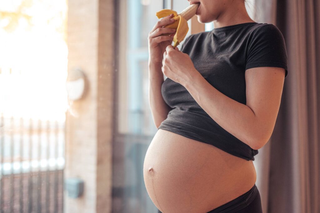 Pregnant Woman Eating a Banana After Workout Free Photo