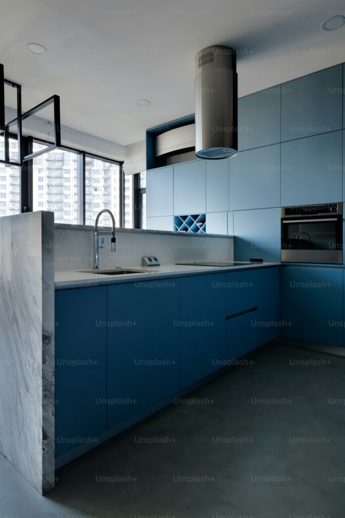 a kitchen with blue cabinets and a marble counter top