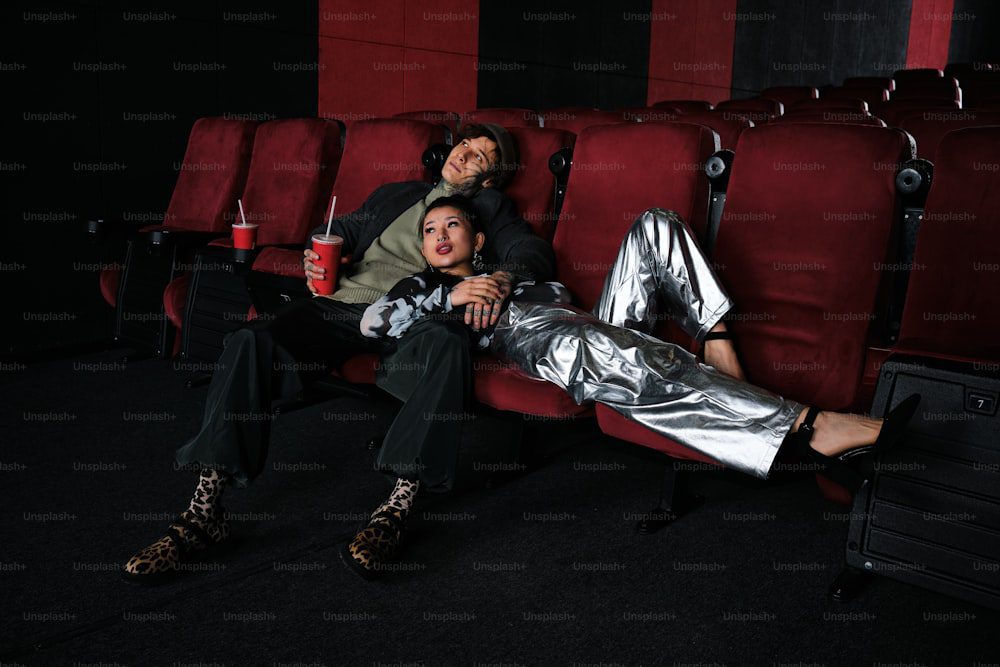 a couple of people that are sitting on a red chair