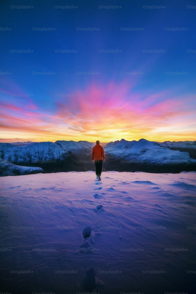 a man standing on top of a snow covered slope