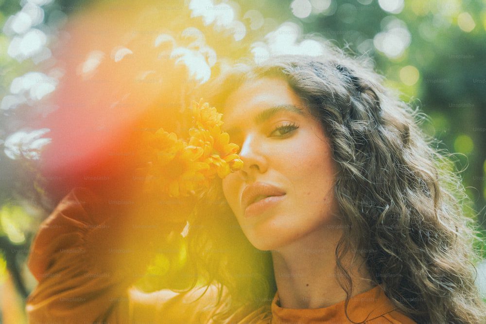 a woman with long hair holding a yellow flower