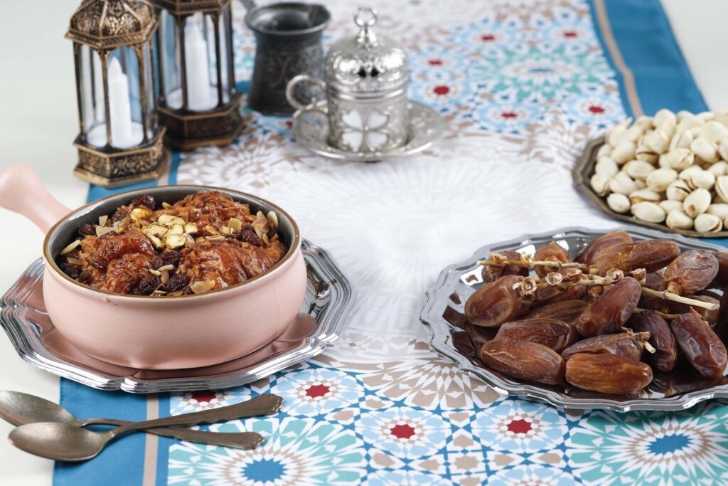 Ramadan Kareem and iftar muslim food, holiday concept. Trays with nuts and dried fruits and latterns with candles. Celebration idea Stock Free