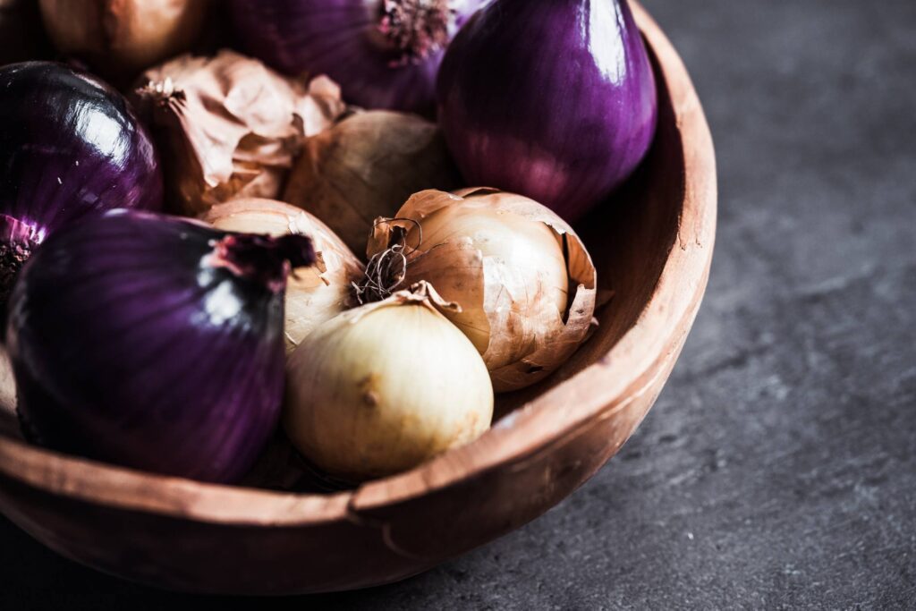 Red and Yellow Onions in a Wooden Bowl Free Photo