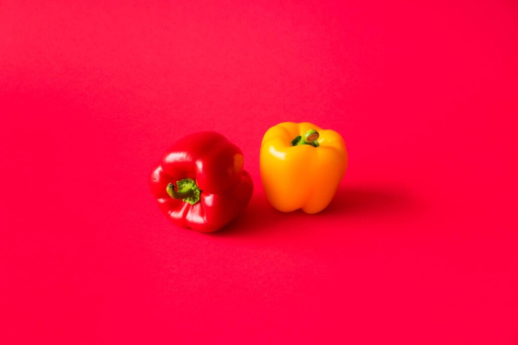 Red and Yellow Paprika Peppers on Flat Background Still Life Free Photo