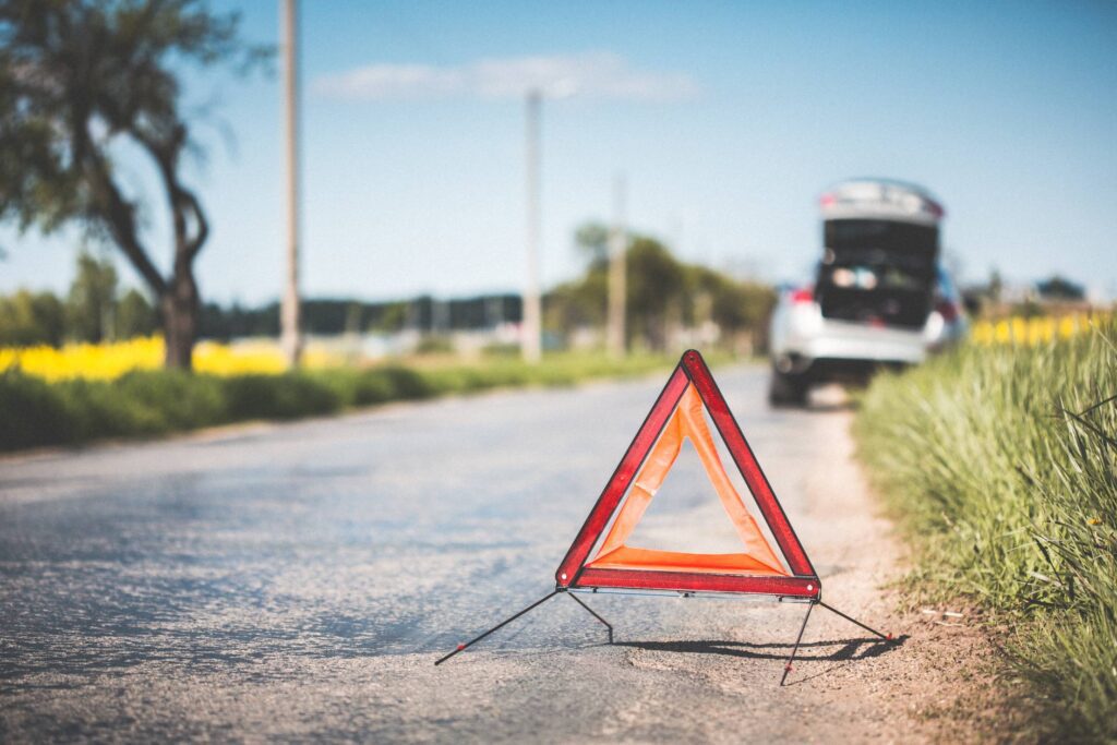 Red Warning Triangle and Broken Car on The Road Free Photo