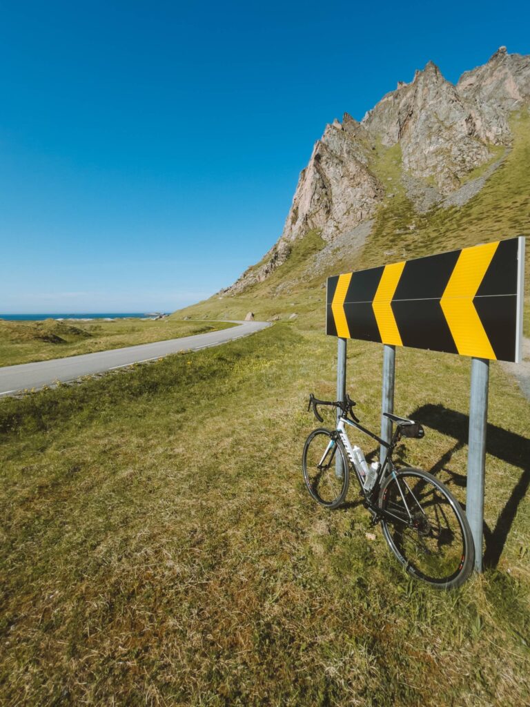 Road Bike and a Road Sign on a Coastal Road Free Photo