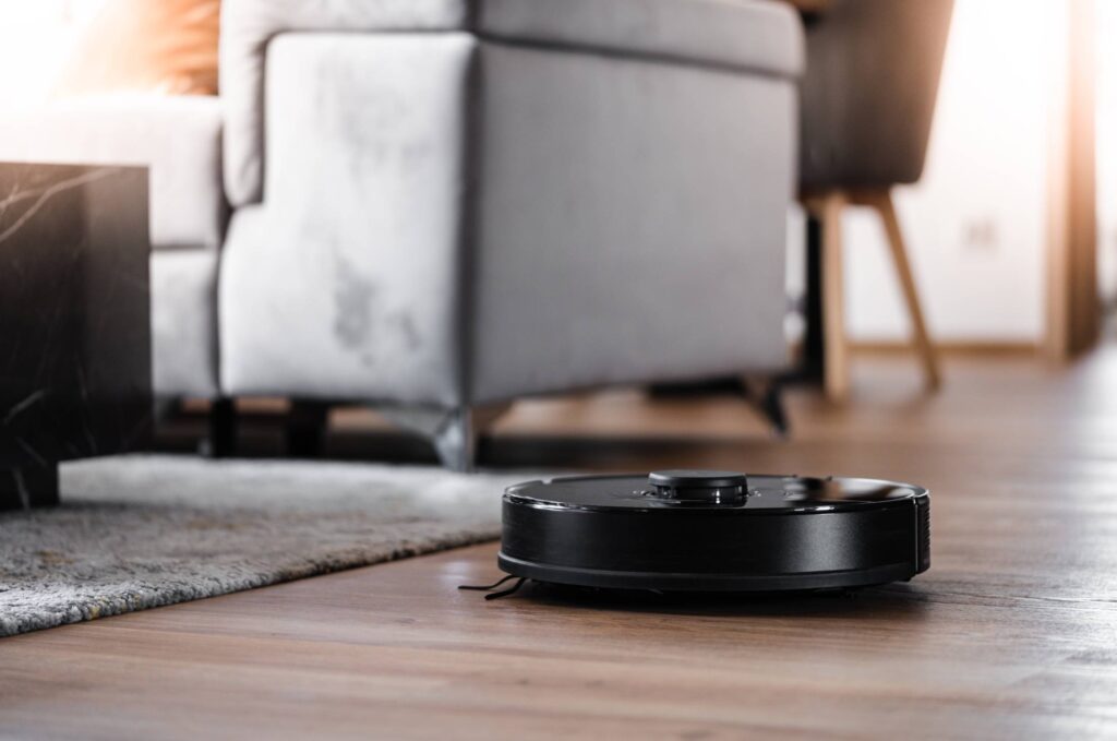 Robotic Vacuum Cleaner Cleaning the Living Room Floor Free Photo