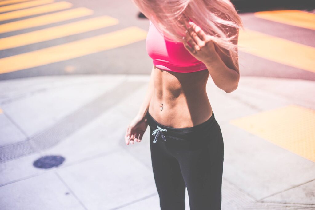 Sexy Fitness Girl Looking Down on Her Shoes Free Photo