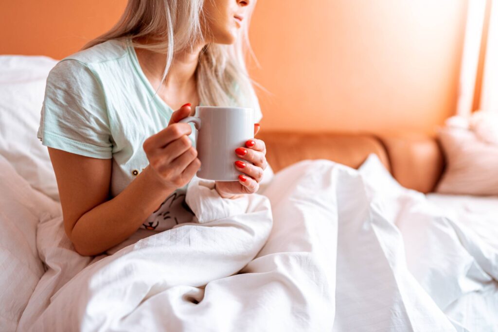 Sick Woman Holding a Cup of Tea Free Photo