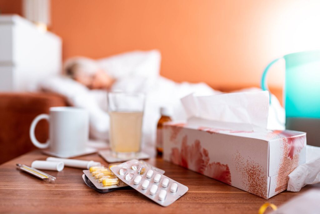 Sick Woman Sleeping in a Bed with a Focus to a Pack of Tablets Lying on The Table Free Photo