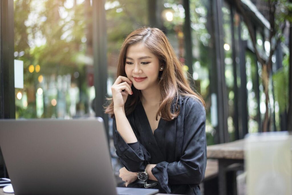 Smart Asian female is working with laptop computer Stock Free