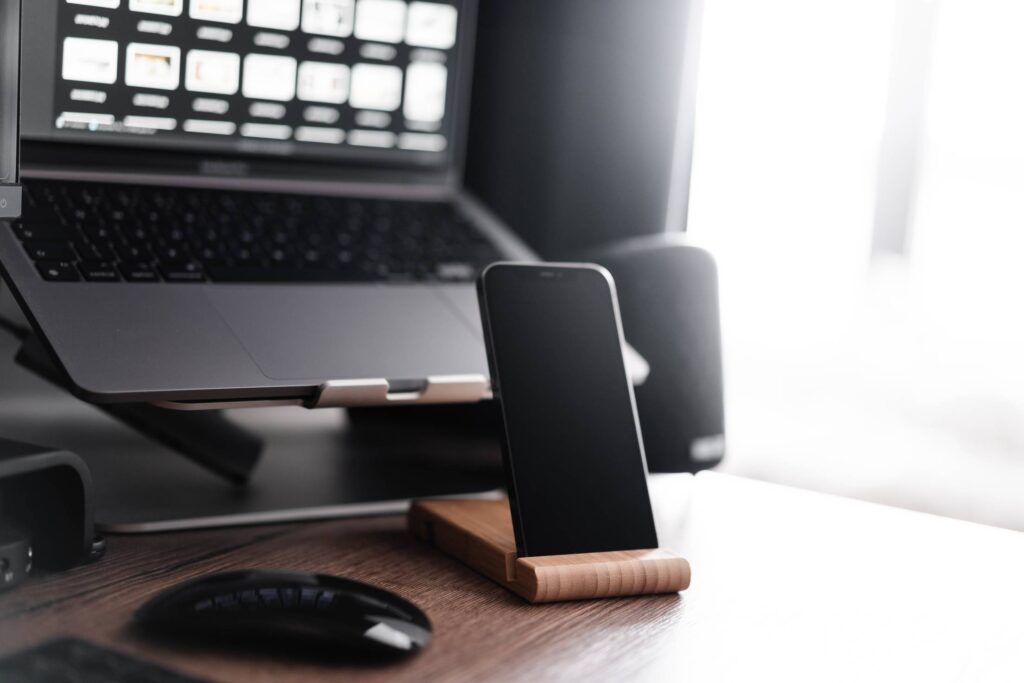 Smartphone in a Wooden Holder Apple Work Desk Setup Free Photo