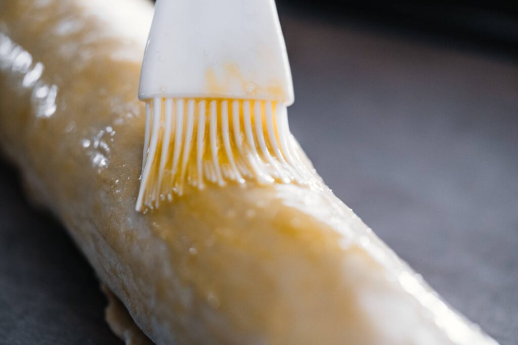 Smearing Raw Apple Strudel with Brush in Yolk Free Photo