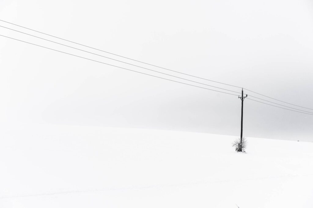 Snow Covered Hill and an Old Power Line Minimalistic Free Photo