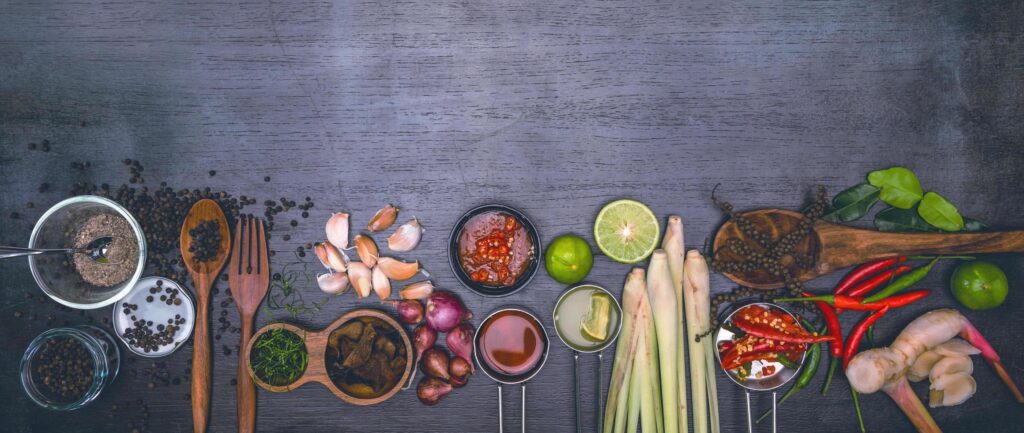 Spices for use as cooking ingredients on a wooden background with Fresh vegetables. Healthy food herbs and spices. Organic vegetables on the table. Free Photo