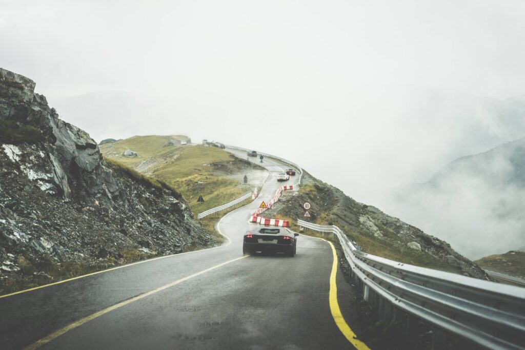 Sport Cars on Wet Mountain Road in Rainy Weather Free Photo