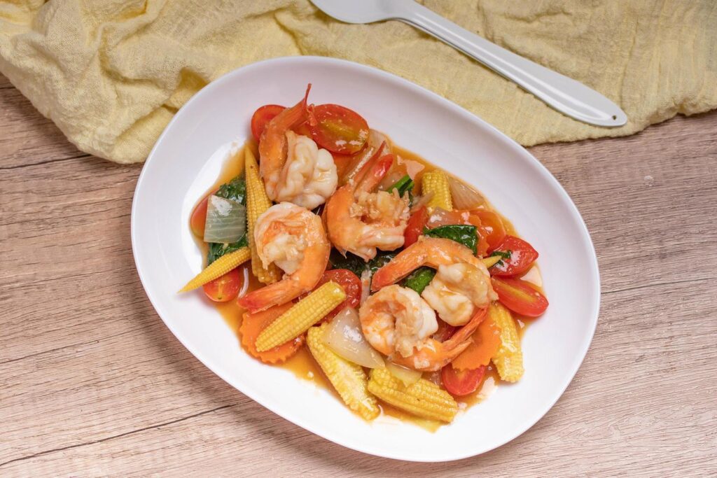 Stir-fried mixed vegetables with shrimp. In a white plate, healthy food concept. Stock Free