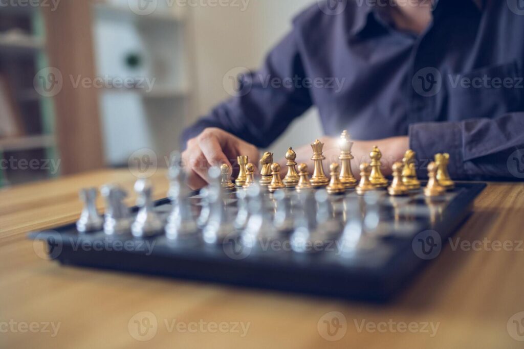 Strategic contemplation in action with a person making a chess move, focus on the golden and silver pieces. Business strategy success concept Pro Photo